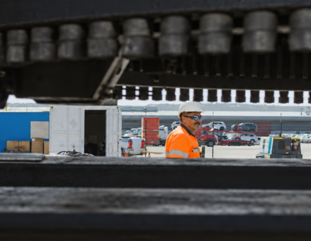 An RJ Holley operator at work, viewed through heavy equipment